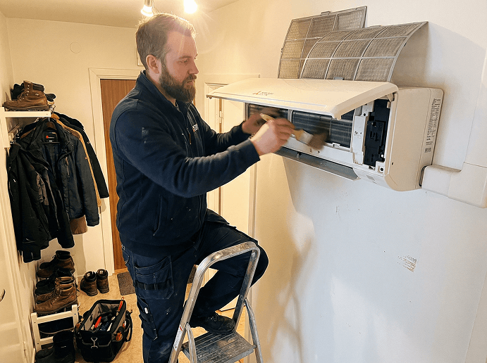 Tekniker utför service på luftvärmepump